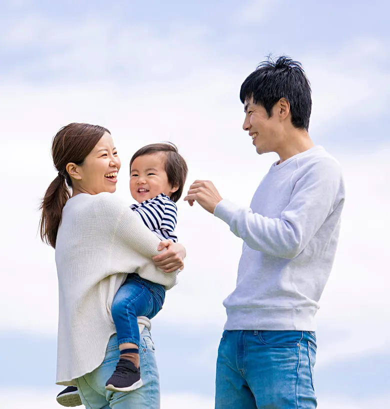 笑顔で赤ちゃんをあやす家族の様子